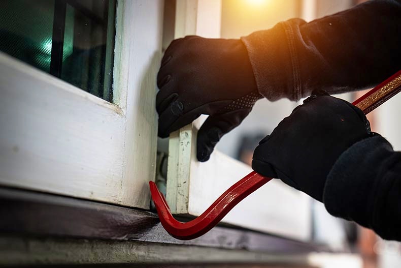 Burglar with Crowbar Breaking into a Home