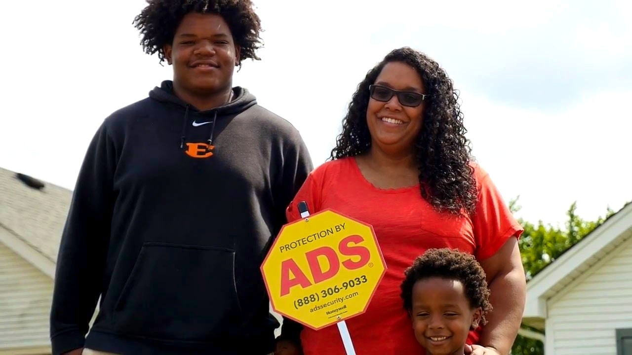 Family of 3 Smiling with ADS Security Sign